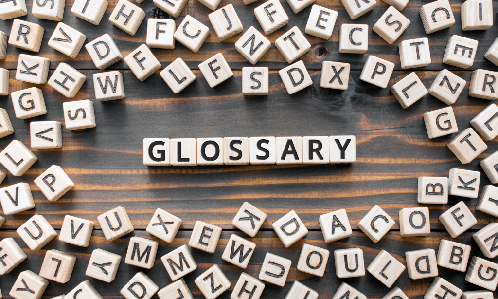 Glossary - word from wooden blocks with letters, alphabetical list with words meanings dictionary glossary concept, random letters around, top view on wooden background
