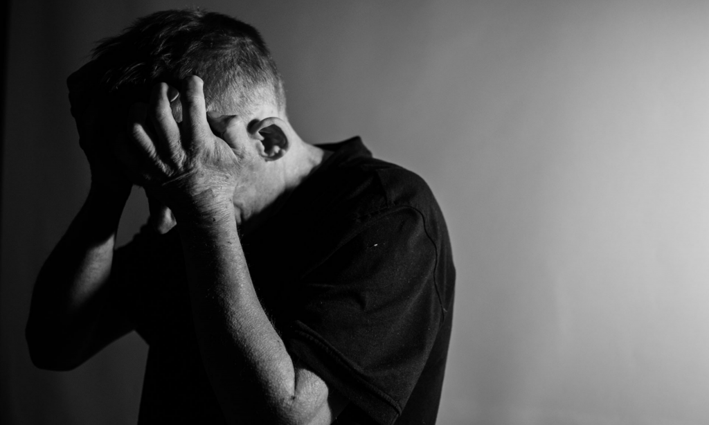 depressed man holding his head in his hands