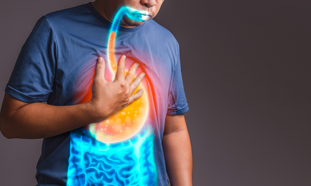 man holding his chest while digital illustration showing up glowing stomach and reflux