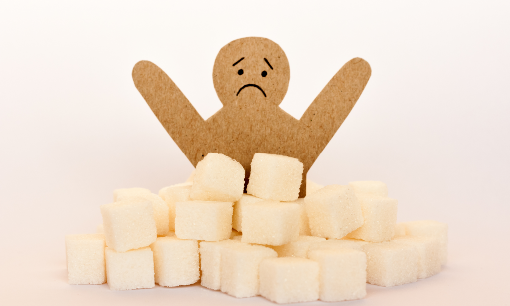 Sugar addiction, insulin resistance, unhealthy diet, figure of a cardboard man surrounded by refined sugar cubes on white background, diabetes protection medical concep