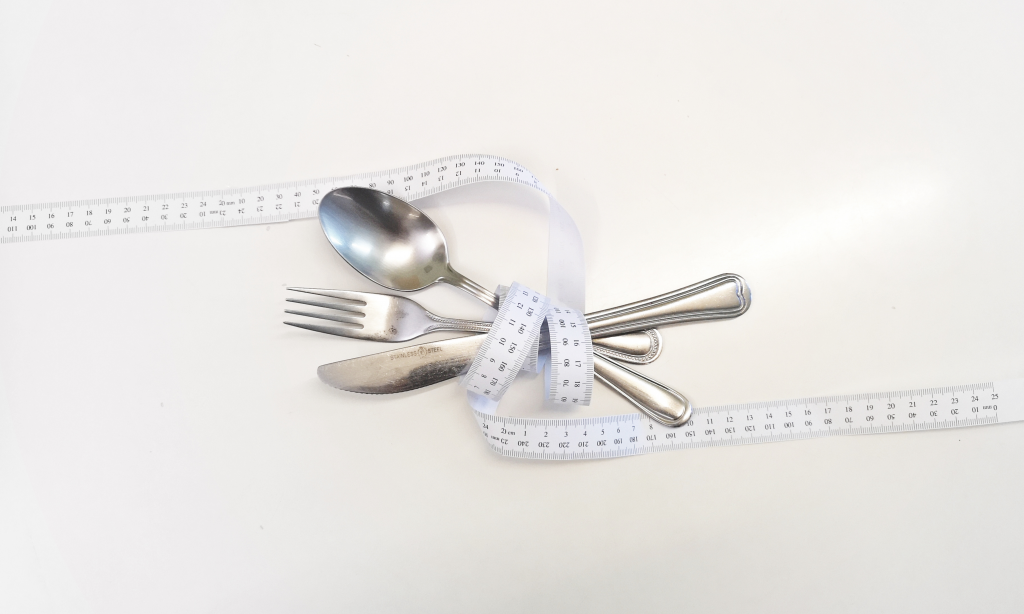 fabric tape measure wrapped around a knife, fork and spoon