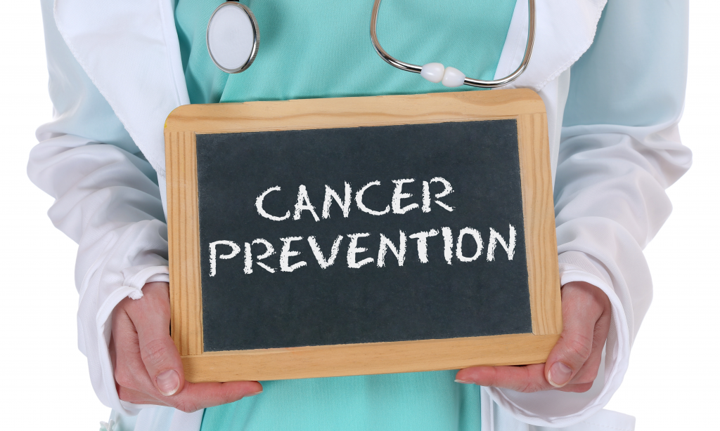 Cancer prevention written on chalkboard being held by medical professional