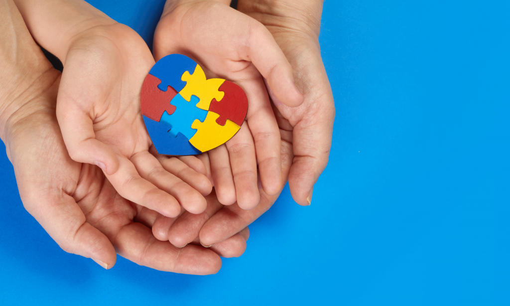 Mental Health Care Concept with Puzzle or Jigsaw Pattern on Heart with Child and Adult Hands