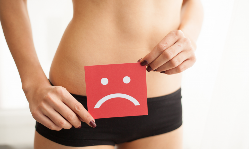 young woman holding sad face over her stomach and lower body