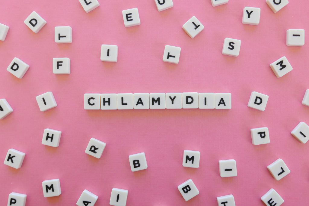 Chlamydia word made of square letter word on pink background.
